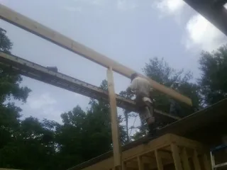 Carpenter setting a ridge beam over a new addition frame — Ice Dam Removal by Roofing Brothers in Zeeland