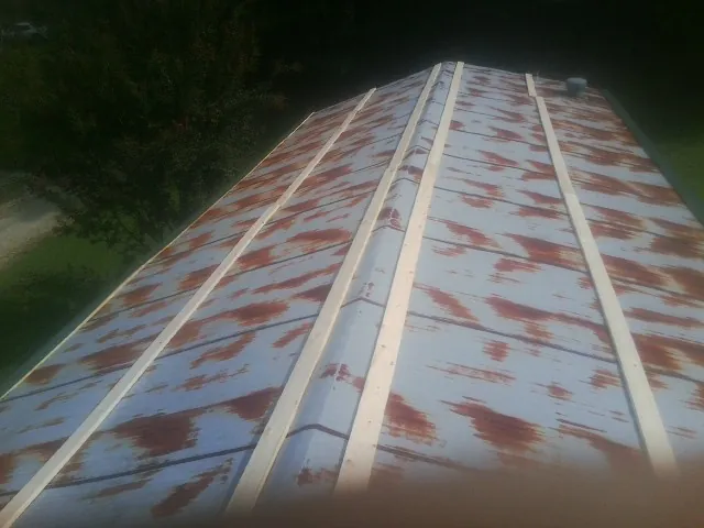 Rusted metal roof panels with new wood purlins before replacement — Storm Damage Roof Repair in Zeeland by Roofing Brothers