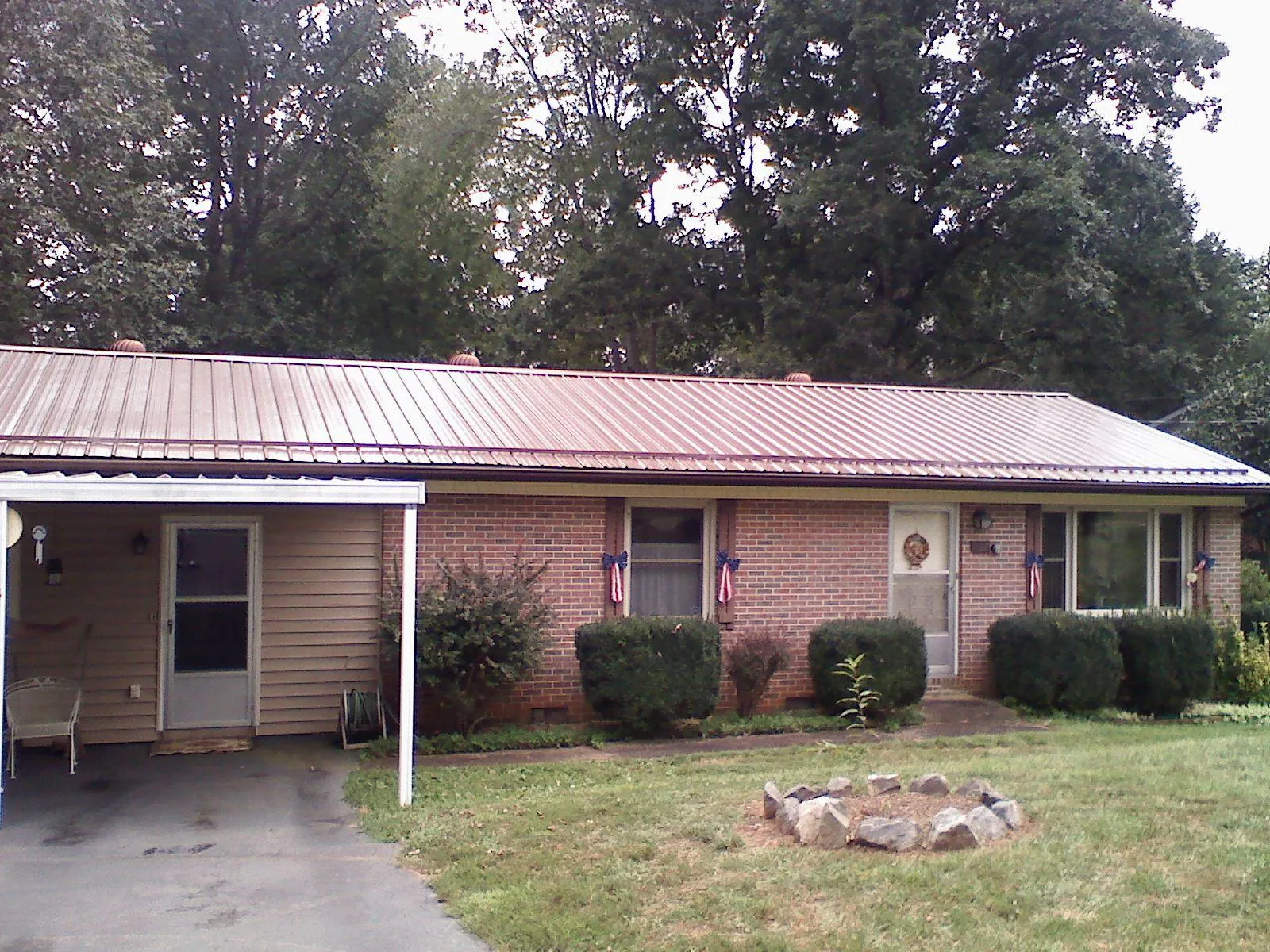 Bronze metal roof and carport on a brick ranch home — Roof Repair work by our crew in Zeeland